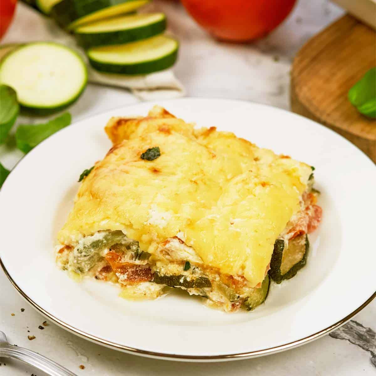 serving of zucchini tomato casserole on a white plate ready to enjoy