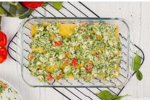 layering ingredients in a baking dish to make Chicken Caesar Lasagna