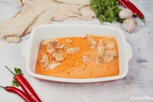 layering ingredients into a baking dish to make Chicken Panang Casserole