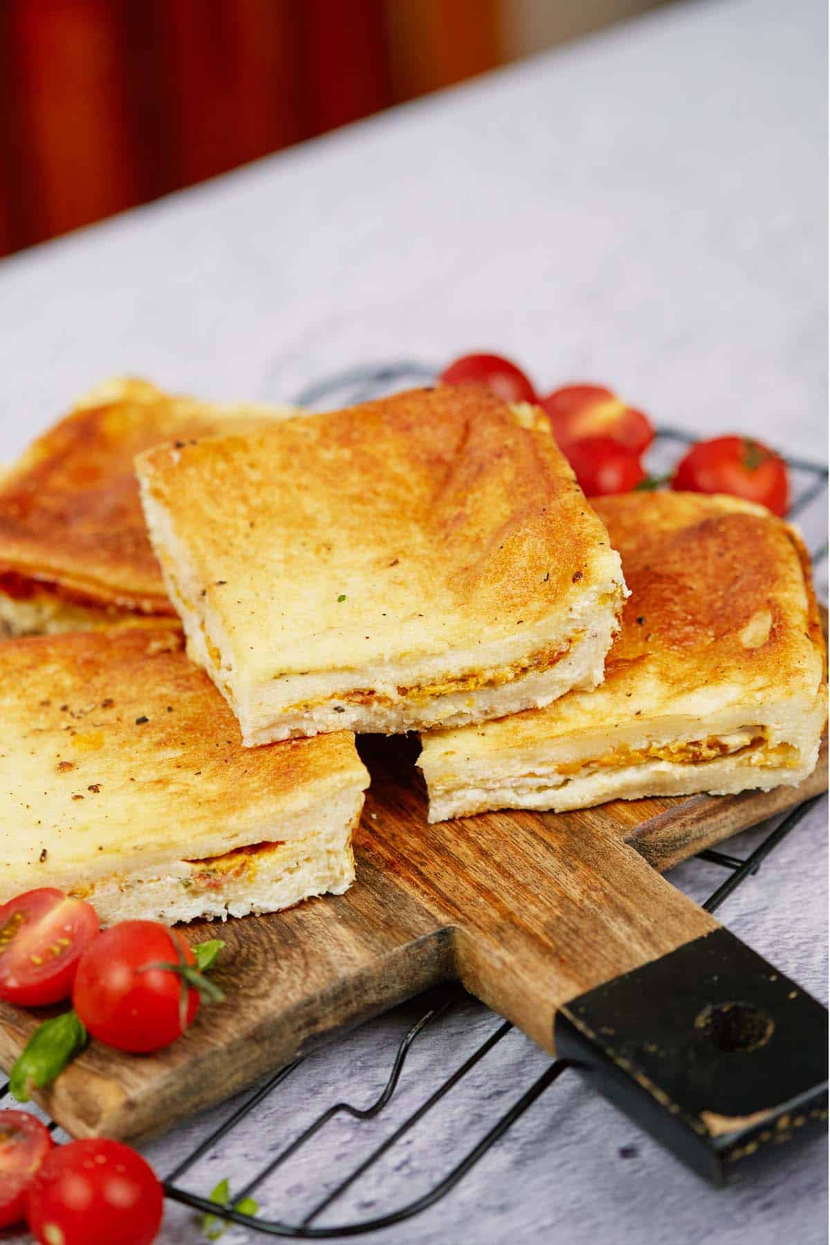 three servings of bacon grilled cheese sandwich casserole on a cutting board ready to serve