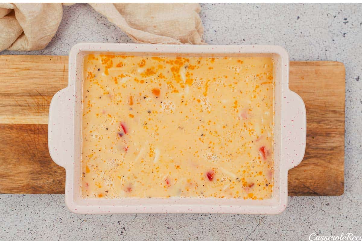 placing ingredients into a baking dish to make baked denver omelette