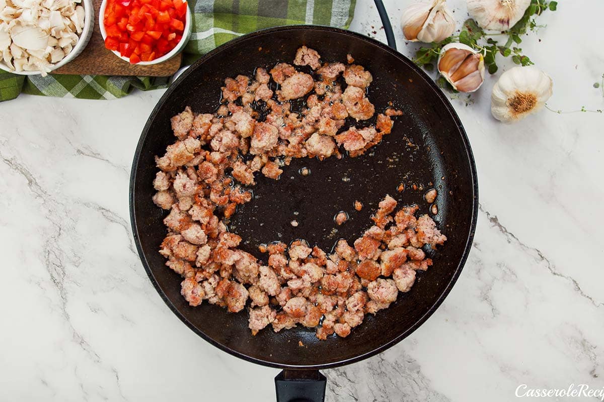 meat being cooked to make noodle pizza casserole