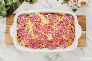 layering ingredients in a baking dish to make noodle pizza casserole