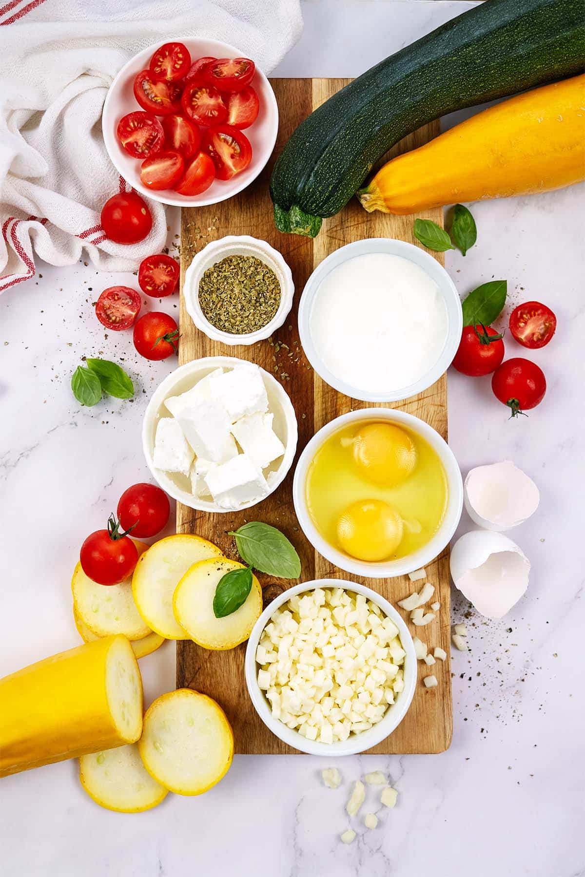ingredients to make oven-baked zucchini fritatta laid out on a table 