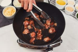 bacon being cooked to make polish cabbage, potato and bacon casserole