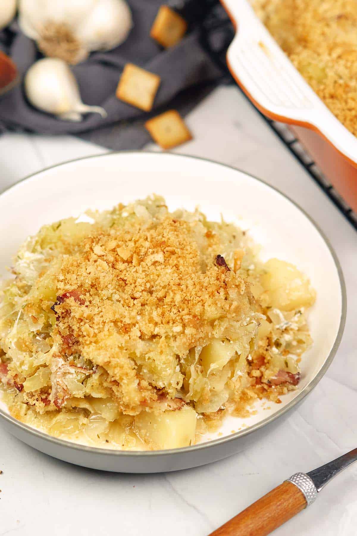 bowl with a serving of polish cabbage, potato and bacon casserole ready to enjoy