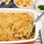 serving of polish cabbage, potato and bacon casserole being lifted out of a baking dish