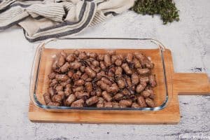 layering sausage mixture in a baking dish to make sausage hashbrown breakfast casserole