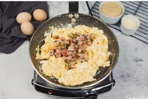 combining ingredients in a pan to sautee together to make scrambled egg casserole