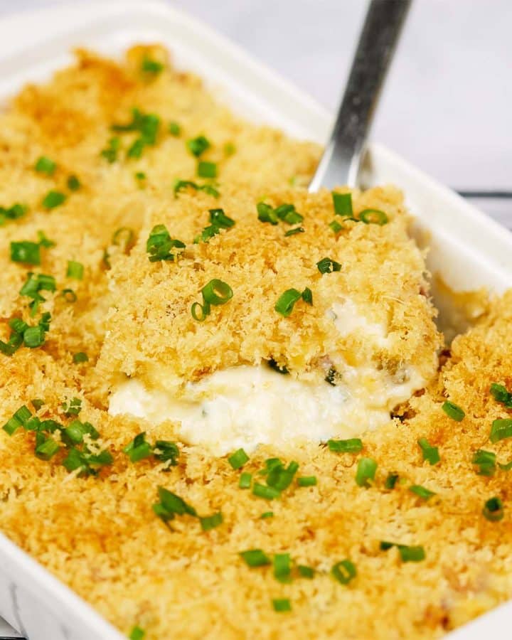 spatula lifting a serving of scrambled egg casserole from a baking dish