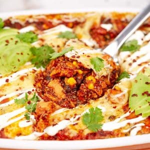 spoon serving a portion of southwest chicken quinoa casserole from a baking dish