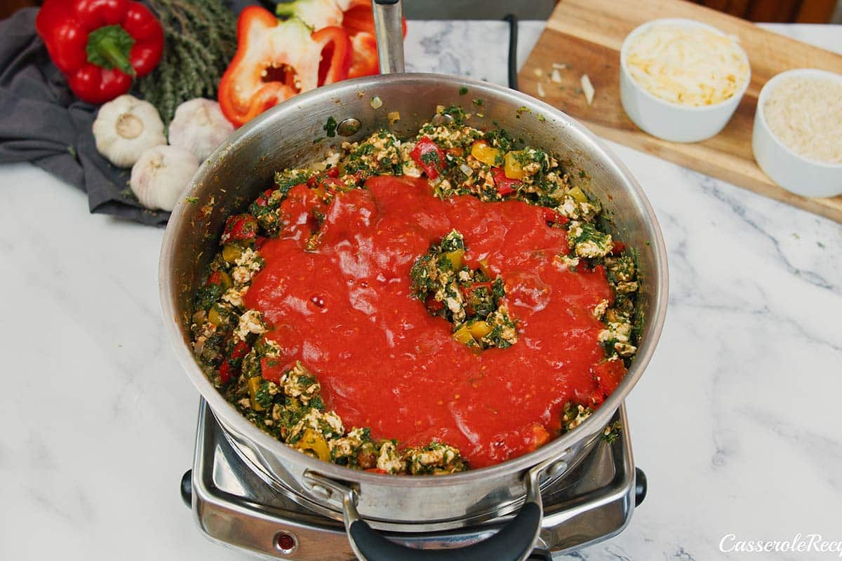 adding ingredients to a dutch oven to make stuffed pepper casserole