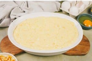 final step of placing the filling in a casserole dish prior to baking to make Corn and Cheese Pashtida Crustless Corn Quiche