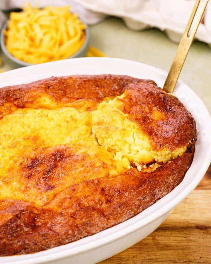 serving of Corn and Cheese Pashtida Crustless Corn Quiche being lifted from a baking dish
