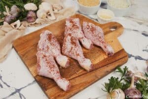 chicken legs being seasoned to make Creamy Orzo Chicken Bake