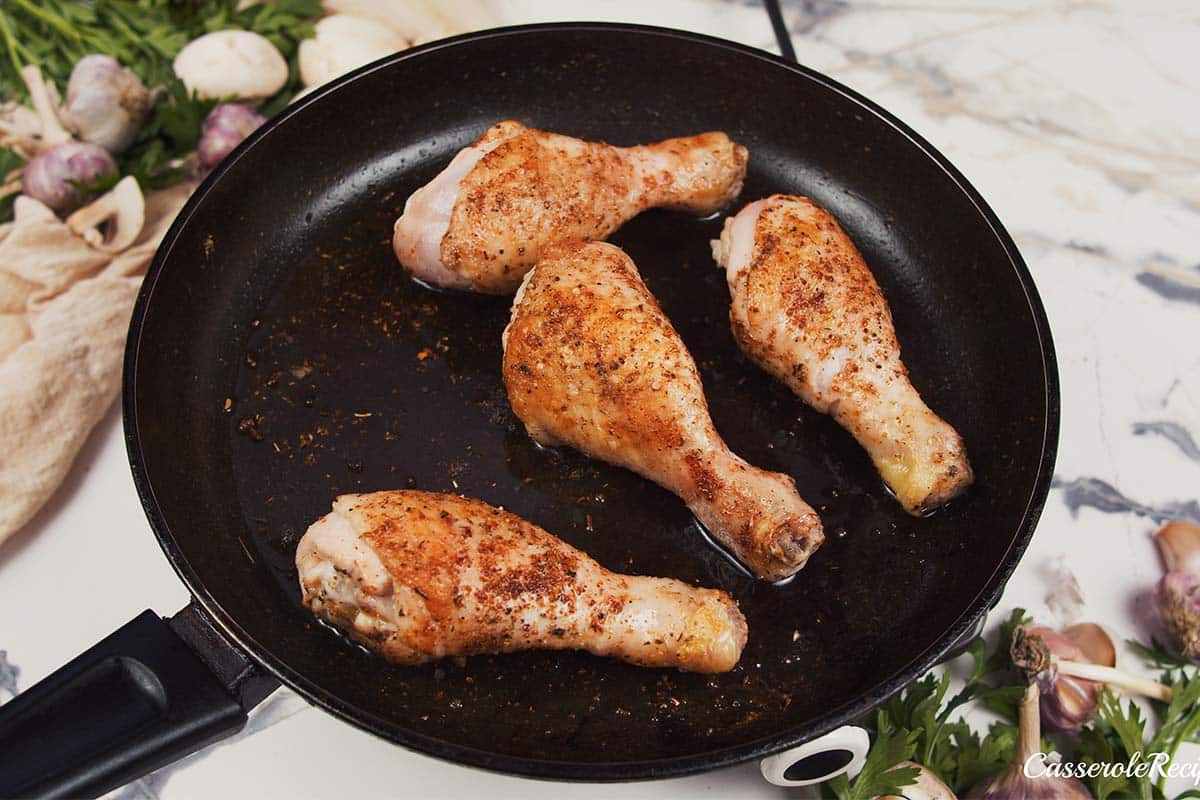 chicken being cooked in a cast iron pan to make Creamy Orzo Chicken Bake