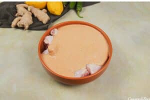 covering the chicken in the prepared curry sauce to make Mum's curried Chicken Bake (tandoori chicken curry)