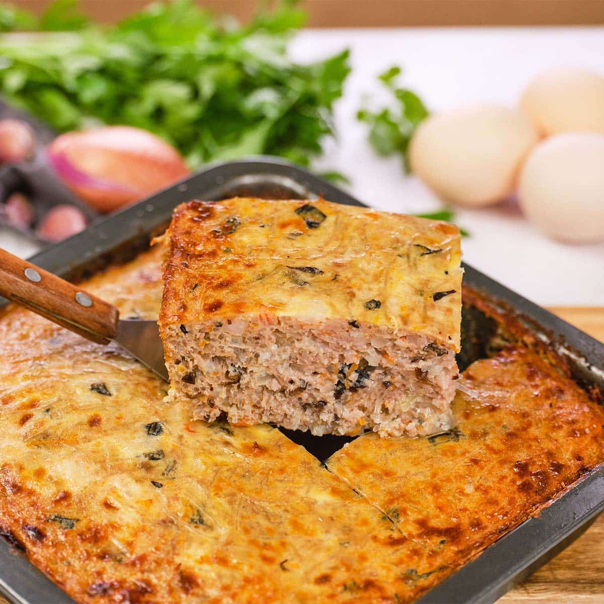 spatula lifting a serving of Vietnamese Pork Bake from a baking dish