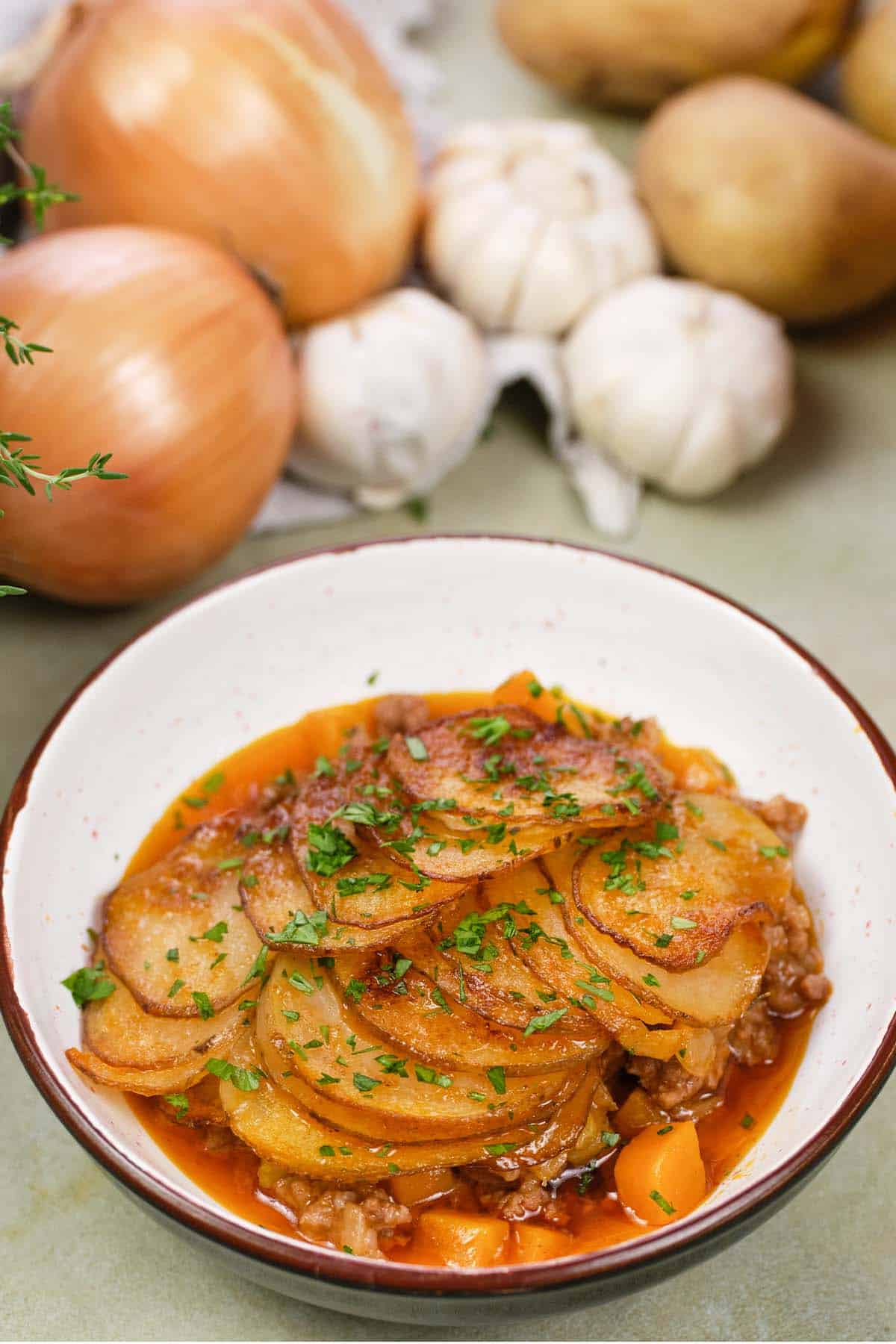 serving of beef hot pot casserole in a bowl on a table with extra ingredients