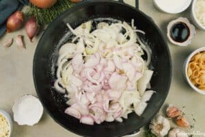 onions and shallots being sauteed together to make caramelized onion pasta bake