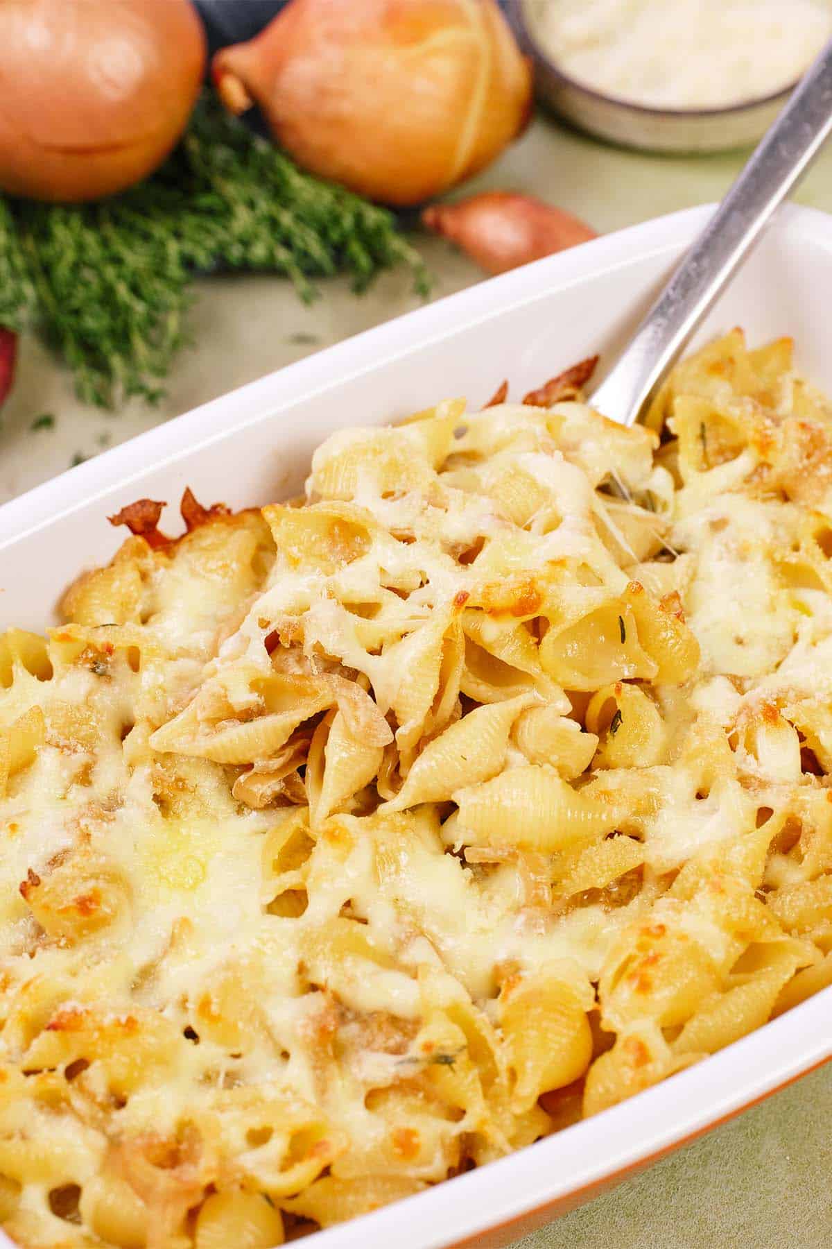 caramelized onion pasta bake being served from a casserole dish