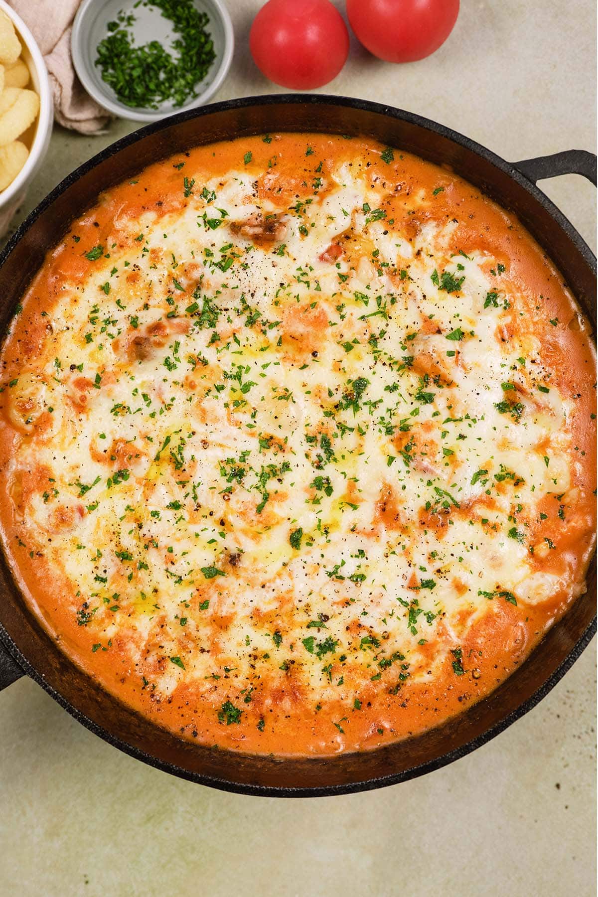 overhead view of chicken and tomato gnocchi bake in a cast iron skillet