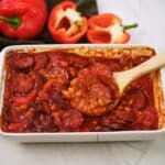 spoon scooping a serving of kielbasa bake from a baking dish