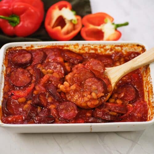 spoon scooping a serving of kielbasa bake from a baking dish