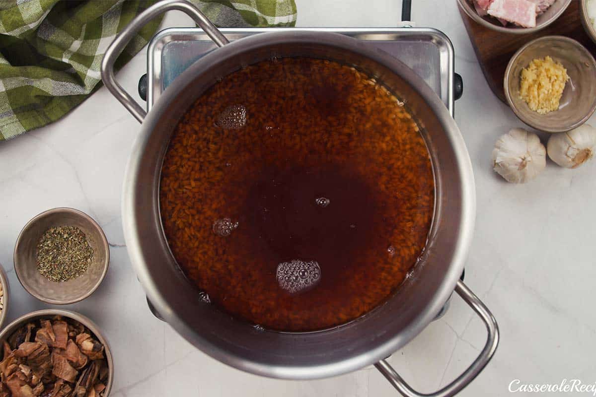 broth being simmered to make mushroom barley casserole