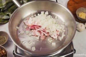 onions being sauteed with bacon to make mushroom barley casserole