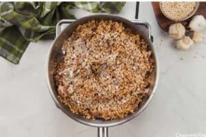 adding barley to saute pan to make mushroom barley casserole