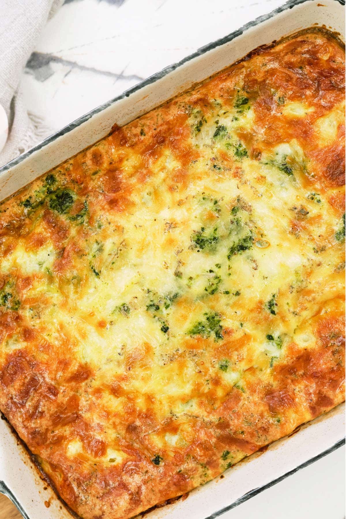 casserole dish of spinach artichoke breakfast casserole ready to serve