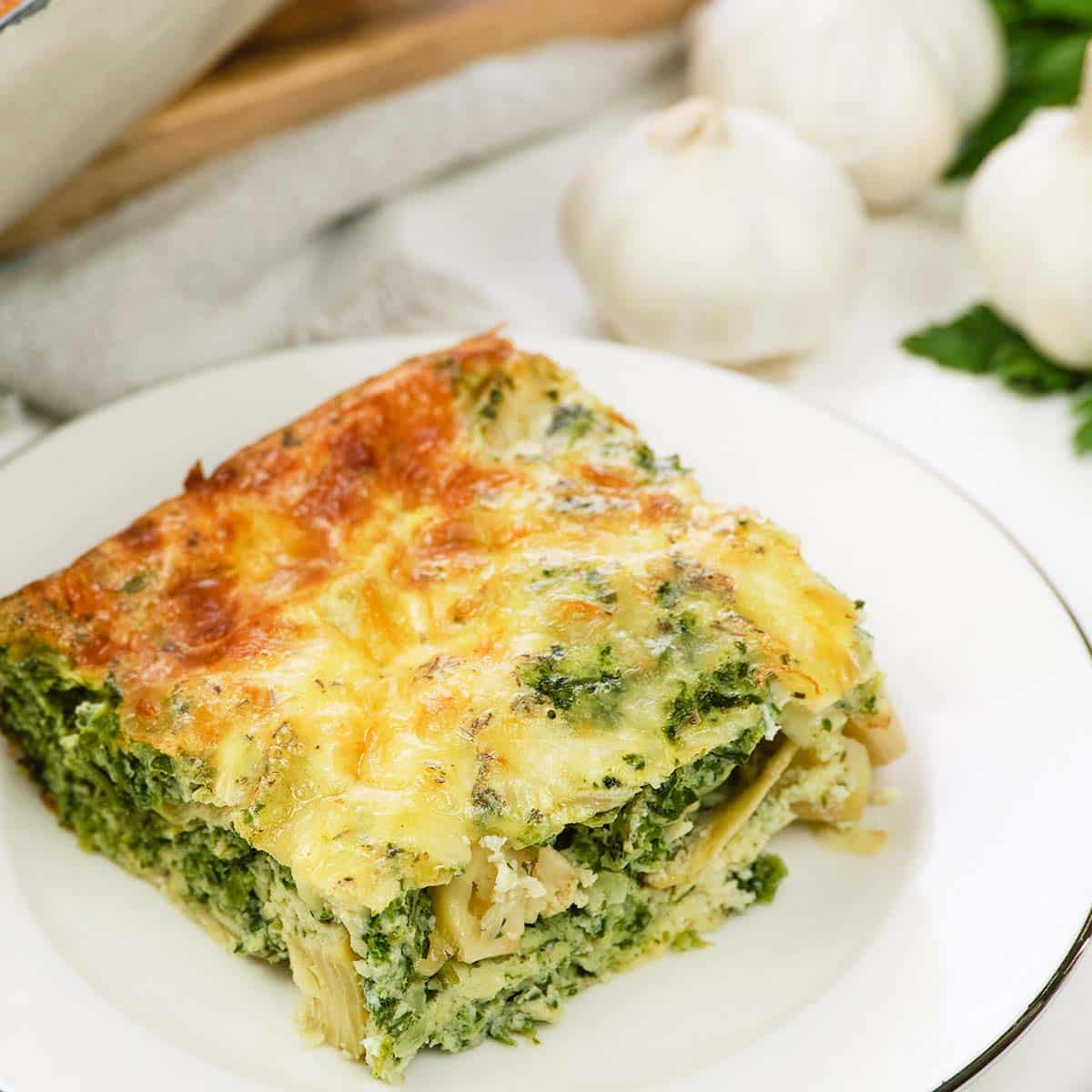 serving of spinach artichoke breakfast casserole on a plate ready to enjoy