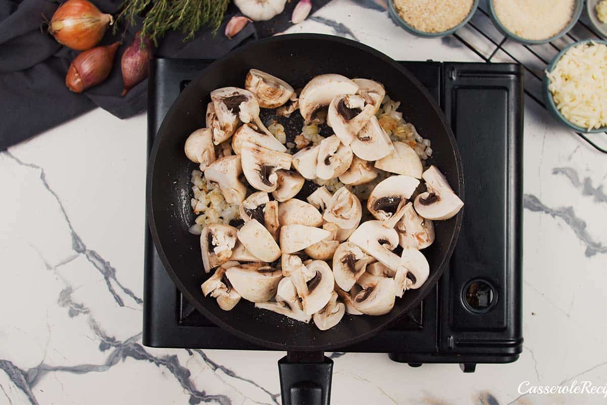 mushrooms and other ingredients being cooked together to make stuffed mushroom casserole