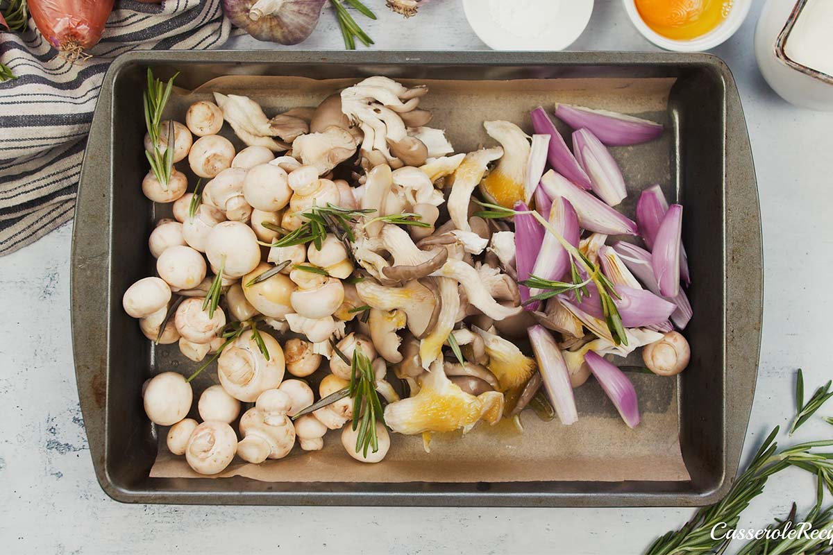 onion and mushrooms on a baking dish with oil on them being prepared to be baked to make yorkshire pudding traybake