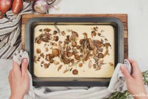 final step of topping yorkshire pudding traybake before baking