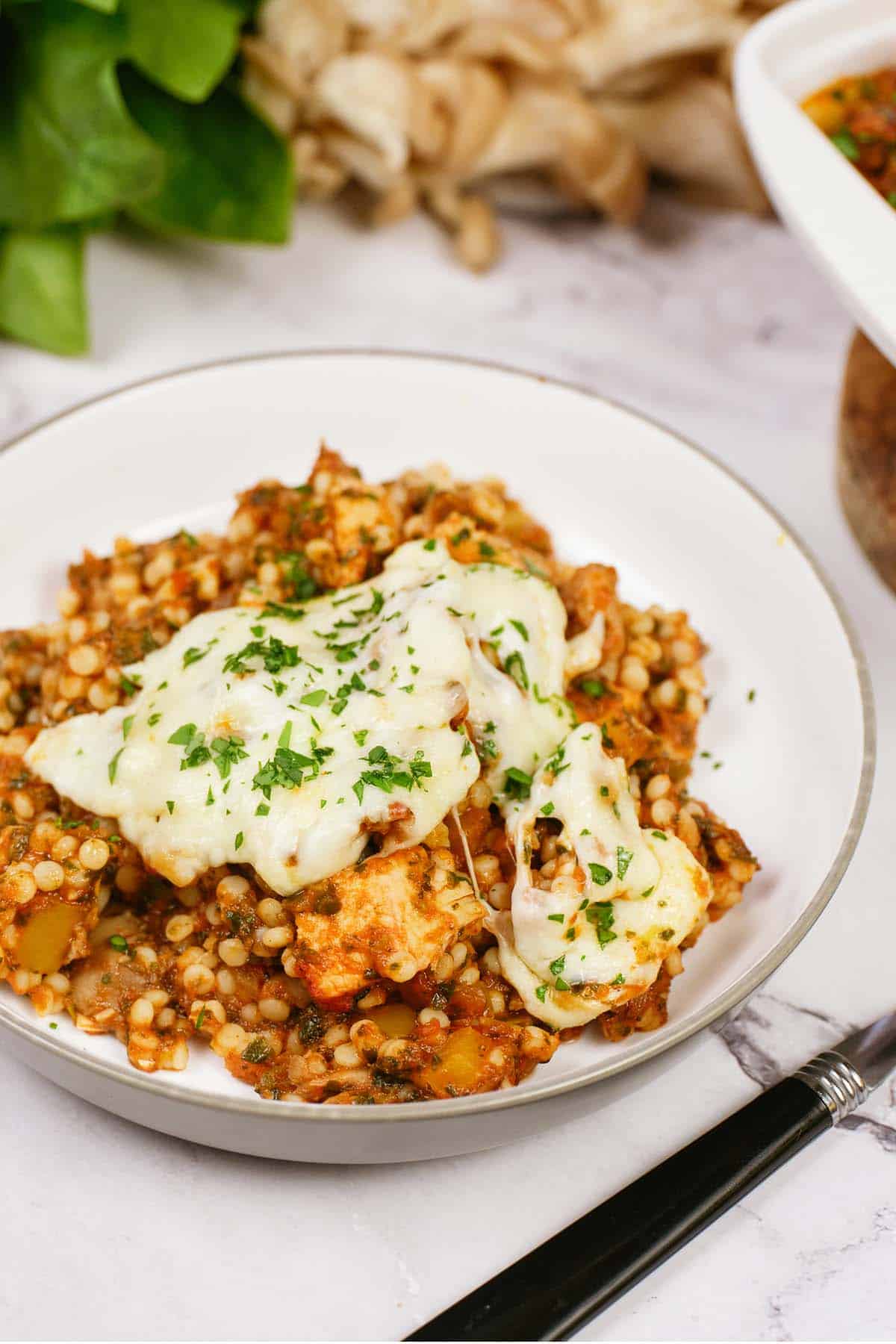 bowl with a serving of Pizza Casserole with Couscous on a table ready to enjoy