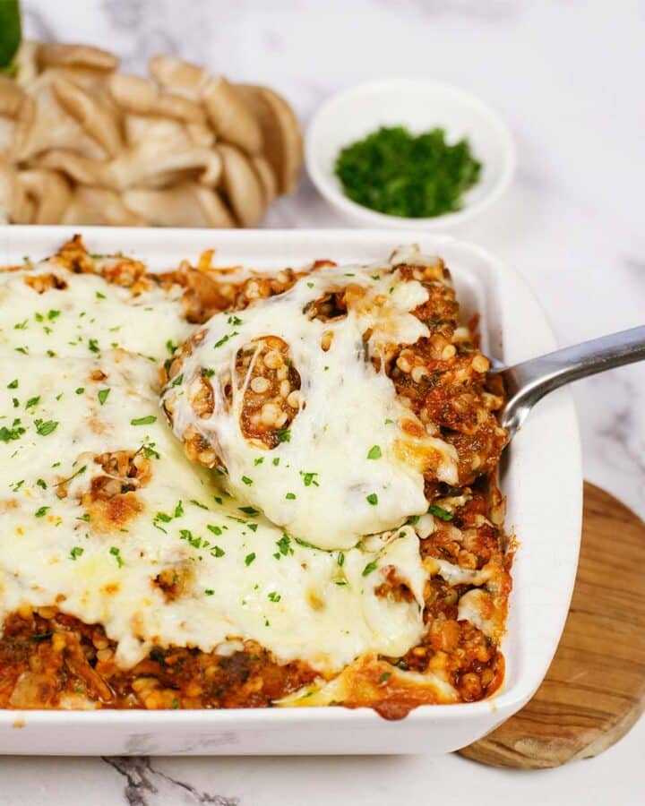 spoon lifting a serving of Pizza Casserole with Couscous from a casserole dish