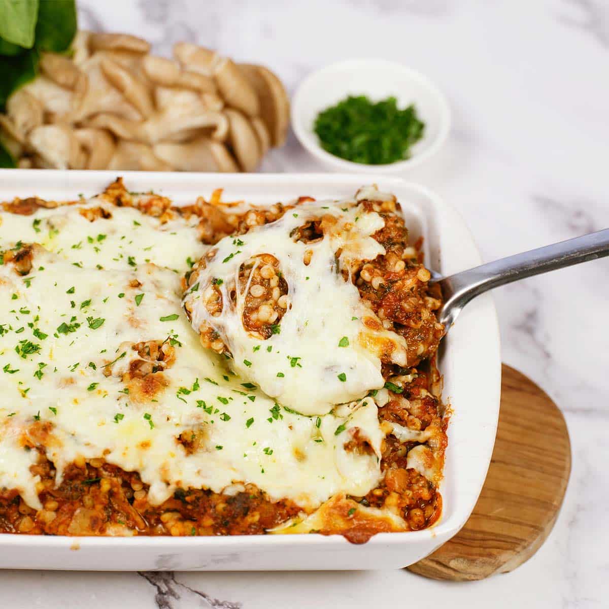 spoon lifting a serving of Pizza Casserole with Couscous from a casserole dish