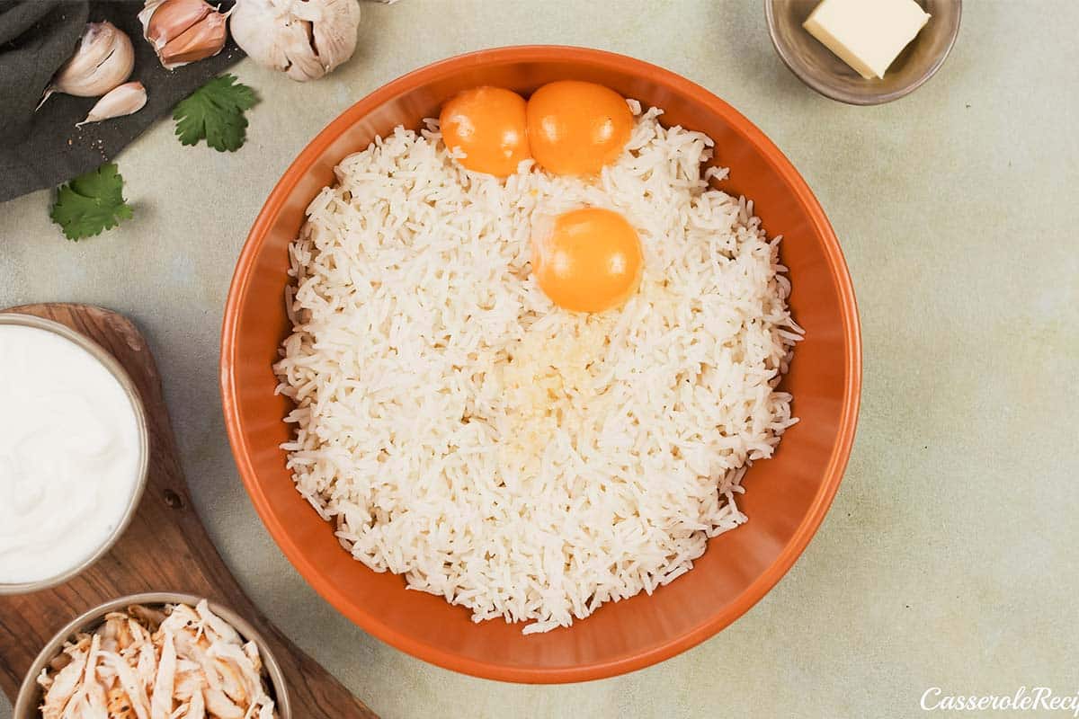 ingredients being combined in a bowl to make Tah-Cheen (persian baked chicken and rice)
