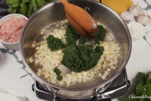 spinach being added to onions to sautee together to make baked skillet lasagna