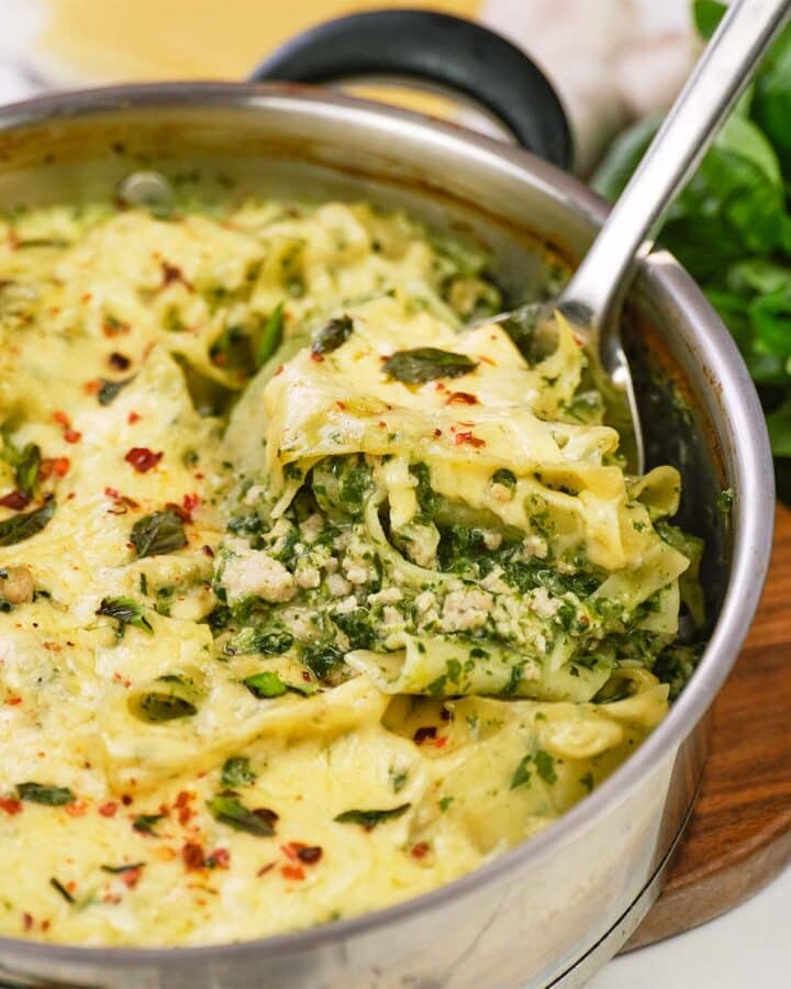 skillet of baked skillet lasagna being served with a large spoon