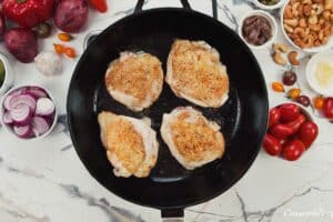 chicken being browned to make chicken bake with anchovy cashew