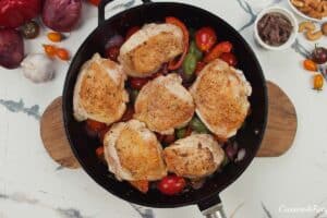layering chicken in among the other ingredients to make chicken bake with anchovy cashew