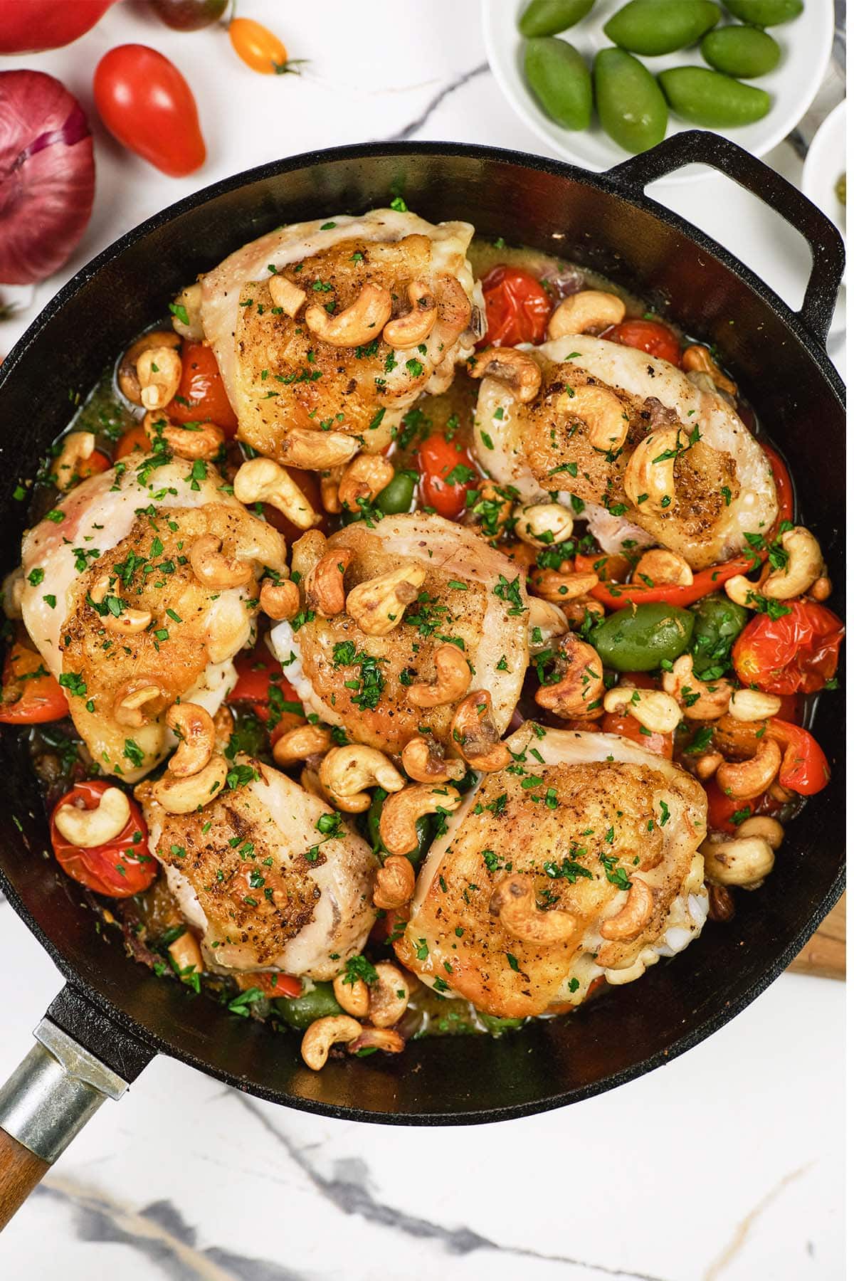 cast iron skillet of chicken bake with anchovy cashew ready to serve
