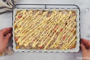 final step of drizzling cheese over the top of the filling prior to baking french fry casserole