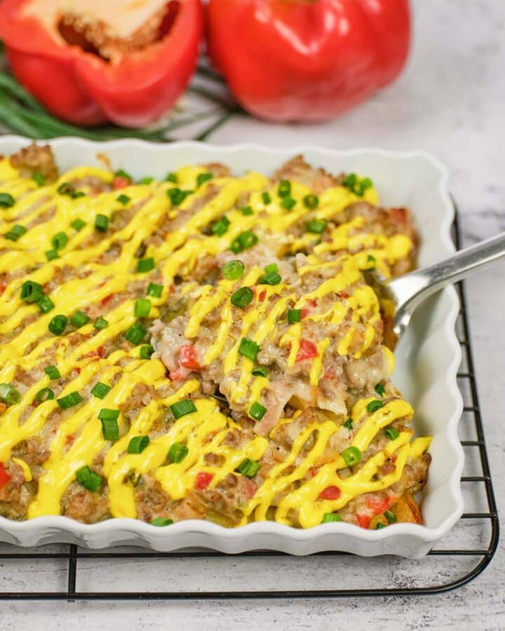 spoon scooping up a serving of french fry casserole from a baking dish