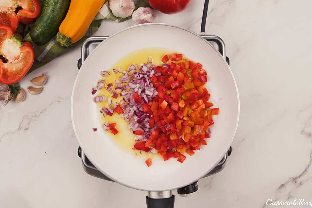 onions and bell pepper being sauteed to make greek casserole with zucchini dumplings