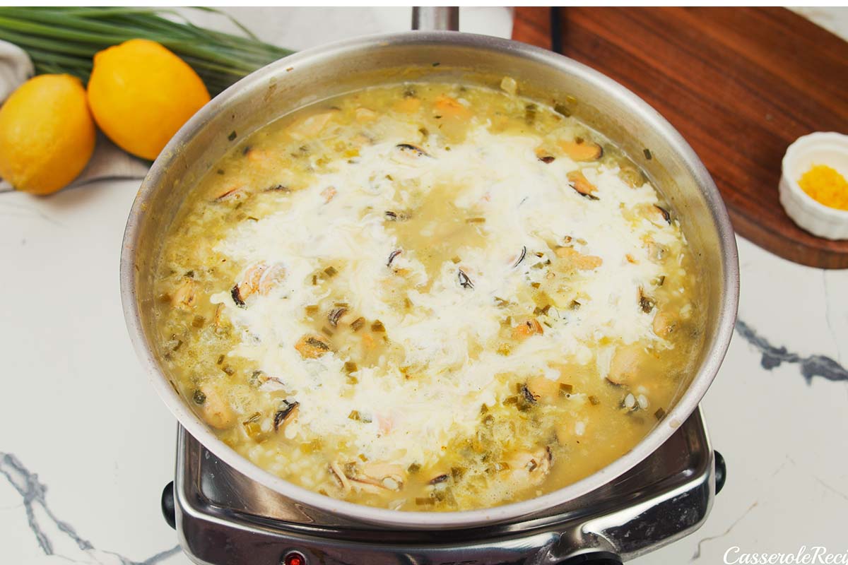 adding cream and stock to other ingredients to make greek rice and mussel casserole