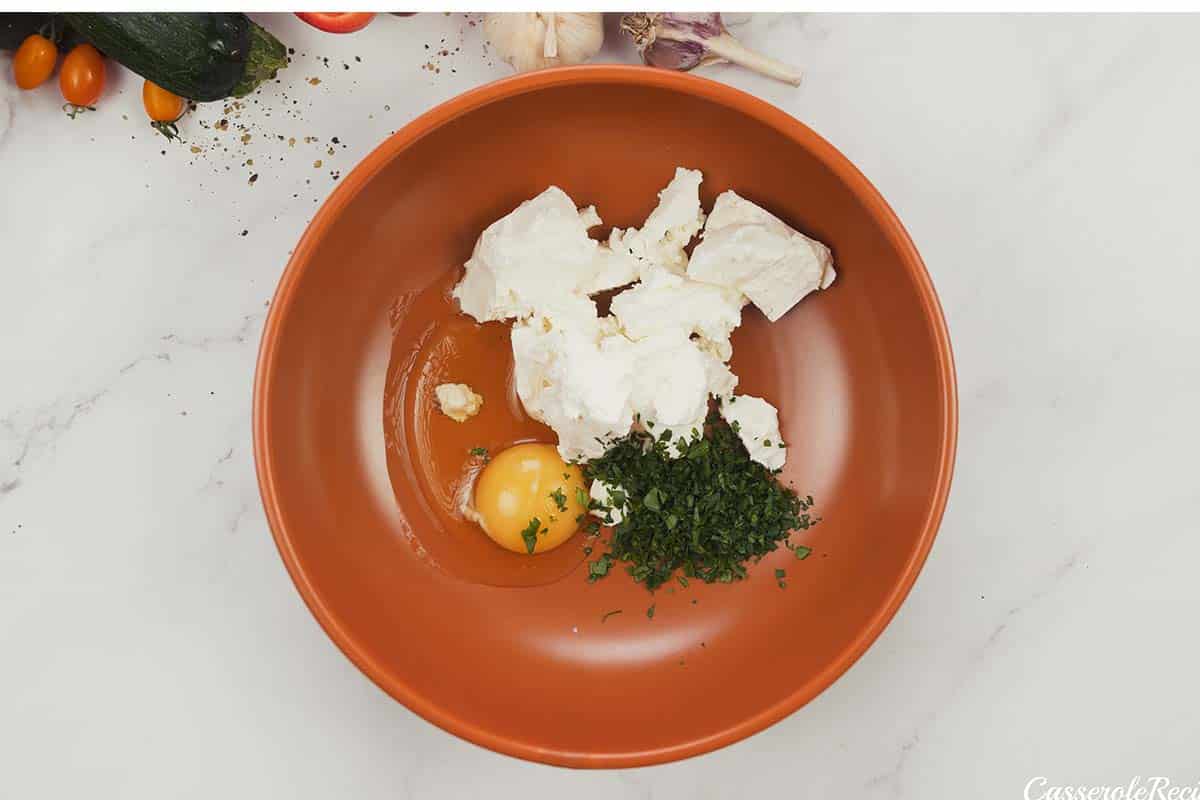 combining egg and cheese to make greek vegetable casserole